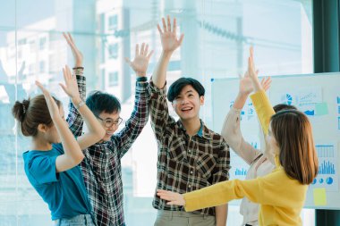 Asyalı iş kadınlarının ve erkeklerin mutlu yeni nesli. Başarılı iş kadını, çalışan, resmi giyinmiş iş arkadaşı, etkinliğin başarısını el sıkışarak ve el sıkışarak kutluyorlar.