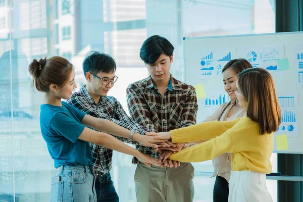 Asyalı iş kadınlarının ve erkeklerin mutlu yeni nesli. Başarılı iş kadını, çalışan, resmi giyinmiş iş arkadaşı, etkinliğin başarısını el sıkışarak ve el sıkışarak kutluyorlar.