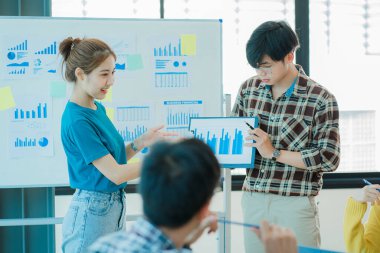 Asyalı yaratıcı takımlar bir atölyede ilham verici yaratıcılığı paylaşmak için birlikte oturup çalışırlar. Genç modern iş adamları iş yerinde grafik kağıdı ve dizüstü bilgisayarla buluşuyorlar..