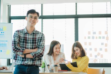 Asyalı yaratıcı takımlar bir atölyede ilham verici yaratıcılığı paylaşmak için birlikte oturup çalışırlar. Genç modern iş adamları iş yerinde grafik kağıdı ve dizüstü bilgisayarla buluşuyorlar..