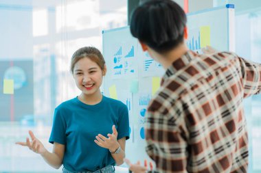 Asyalı yaratıcı takımlar bir atölyede ilham verici yaratıcılığı paylaşmak için birlikte oturup çalışırlar. Genç modern iş adamları iş yerinde grafik kağıdı ve dizüstü bilgisayarla buluşuyorlar..