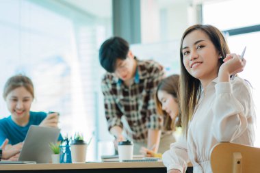 Asyalı yaratıcı takımlar bir atölyede ilham verici yaratıcılığı paylaşmak için birlikte oturup çalışırlar. Genç modern iş adamları iş yerinde grafik kağıdı ve dizüstü bilgisayarla buluşuyorlar..