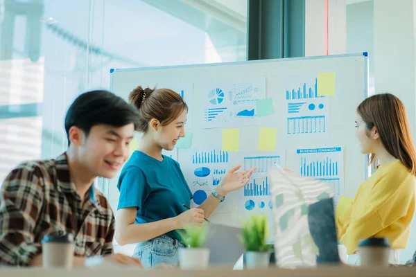 Asyalı yaratıcı takımlar bir atölyede ilham verici yaratıcılığı paylaşmak için birlikte oturup çalışırlar. Genç modern iş adamları iş yerinde grafik kağıdı ve dizüstü bilgisayarla buluşuyorlar..