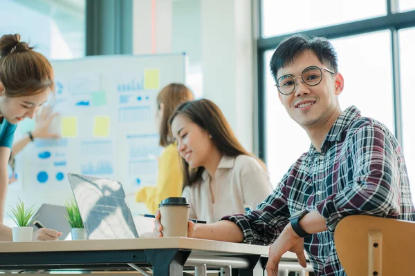 Asyalı yaratıcı takımlar bir atölyede ilham verici yaratıcılığı paylaşmak için birlikte oturup çalışırlar. Genç modern iş adamları iş yerinde grafik kağıdı ve dizüstü bilgisayarla buluşuyorlar..