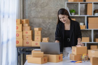 Güzel Asyalı kız serbest KOBİ işi çevrimiçi bilgisayar, dizüstü bilgisayar, akıllı telefon ve paket kutusu üzerinde çalışıyor - çevrimiçi KOBİ iş fikri ve teslimatı.
