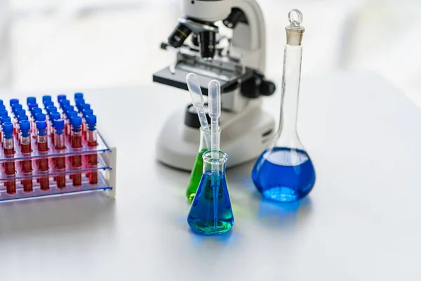 Concept of research and development of science laboratories microscope with beaker and flask with chemical structure blue and red banner background