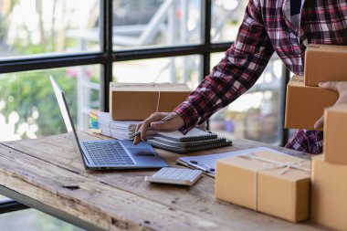 Genç Girişimci Küçük İşletme KOBİ Sahibi Erkek Girişimci Online siparişleri kontrol edin. Hazırlama, paketleme, KOBİ müşterilerine satış, çevrimiçi iş fikirleri, evde satış