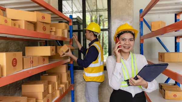 man, woman, asia, helmet, safety, employee, check, order, shelves, shipping, manager, storage, factory, industries, carrying, boxes, logistics, goods, supervisor, engineer delivery concept