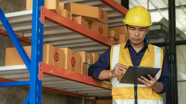 Asian man managing warehouse worker man holding tablet in warehouse Logistics network distribution and intelligent logistics, import, export, and industrial concepts..box transport