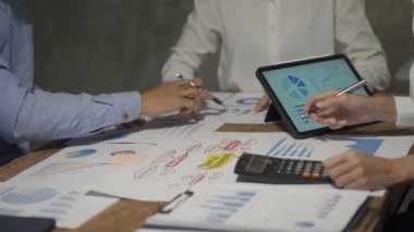 Asyalı iş ekibiyle tanışın, tartışın, beyin fırtınası yapın ve muhasebe konferans odasında dizüstü bilgisayarlarda ve tabletlerde aylık pazarlama raporlarını tartışın. 4K UHD Fazla Mesai Kavramı
