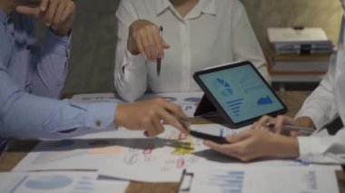 Asyalı iş ekibiyle tanışın, tartışın, beyin fırtınası yapın ve muhasebe konferans odasında dizüstü bilgisayarlarda ve tabletlerde aylık pazarlama raporlarını tartışın. 4K UHD Fazla Mesai Kavramı