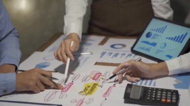 Asyalı iş ekibiyle tanışın, tartışın, beyin fırtınası yapın ve muhasebe konferans odasında dizüstü bilgisayarlarda ve tabletlerde aylık pazarlama raporlarını tartışın. 4K UHD Fazla Mesai Kavramı