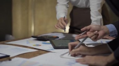 Asyalı iş ekibiyle tanışın, tartışın, beyin fırtınası yapın ve muhasebe konferans odasında dizüstü bilgisayarlarda ve tabletlerde aylık pazarlama raporlarını tartışın. 4K UHD Fazla Mesai Kavramı