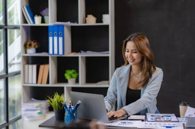 İş kadını, tahtadan masa ve iş geçmişi, vergi, muhasebe, istatistik ve analitik araştırma kavramlarında matematik finansmanı için hesap makinesi kullanıyor..