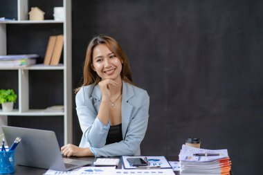 İş kadını, tahtadan masa ve iş geçmişi, vergi, muhasebe, istatistik ve analitik araştırma kavramlarında matematik finansmanı için hesap makinesi kullanıyor..