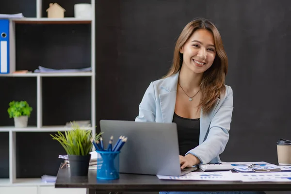 Business woman using calculator for math finance on wooden table and business background, tax, accounting, statistics and analytical research concepts in office.