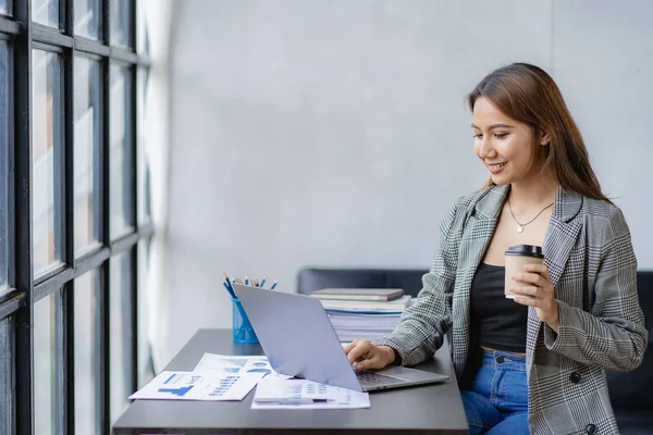 Business woman using calculator for math finance on wooden table and business background, tax, accounting, statistics and analytical research concepts in office.