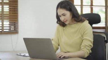 Mutlu Asyalı kadın evde dizüstü bilgisayar kullanarak rahatlıyor. İnternetten alışveriş yapmayı ve çalışmayı seviyorum.