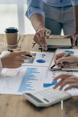 Takım çalışması kavramı, finansal danışmanlık ofisinde finansal rapor verilerini analiz etmek ve tartışmak ve beyin fırtınası yapmak için toplanan bir grup iş adamı. dikey resim