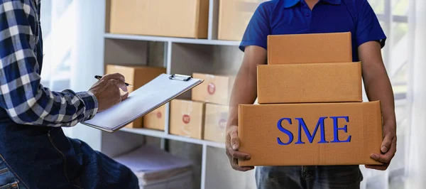 Operators work on receiving boxes and check online orders to prepare the packaging. Sell to customers. SME business concept online e-commerce