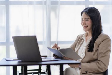 Asyalı iş kadını evdeki müşterilerle internet üzerinden iletişim kuruyor. ev konseptinden çevrimiçi çalışma