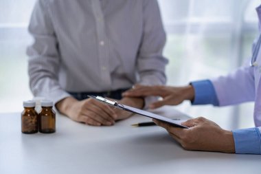 Doktorlar ve hastalar oturup hastalarla ilaçlar hakkında konuşurlar. Hastanenin penceresinin yanındaki masada. Danışmanlık ve tavsiye konsepti.