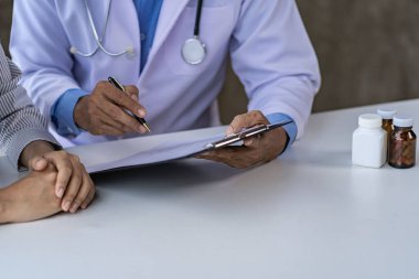 Doktorlar ve hastalar oturup hastalarla ilaçlar hakkında konuşurlar. Hastanenin penceresinin yanındaki masada. Danışmanlık ve tavsiye konsepti.