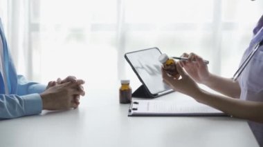 Kadın doktor erkek hastaya danışmanlık yapıyor. Tedavi geçmişinizi okuyun ve klinik muayenelerinizde konuşun. Erkek hastalar için profesyonel tıbbi tedavi