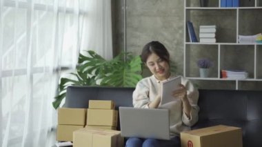 Asyalı kadın küçük internet işletme sahibi ev bilgisayarında dağıtıma paket hazırlıyor KOBİ girişimcisi çevrimiçi alışveriş konsepti