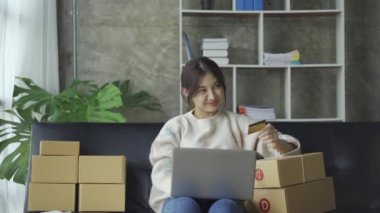 Asyalı kadın küçük internet işletme sahibi ev bilgisayarında dağıtıma paket hazırlıyor KOBİ girişimcisi çevrimiçi alışveriş konsepti
