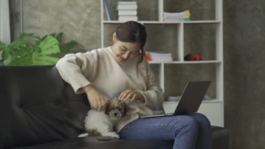 Sosyal medya, online ve Asyalı kadınlar evdeki kanepede dizüstü bilgisayar oynuyorlar İnternet üzerinden alışveriş yapan kızlar