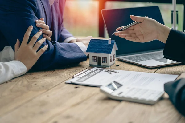 Home agents talk to new homebuyers and offer good interest rates and calculate clients on mortgage financing to help them decide on real estate ideas with insurance.