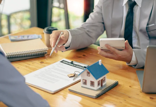 Home agents talk to new homebuyers and offer good interest rates and calculate clients on mortgage financing to help them decide on real estate ideas with insurance.