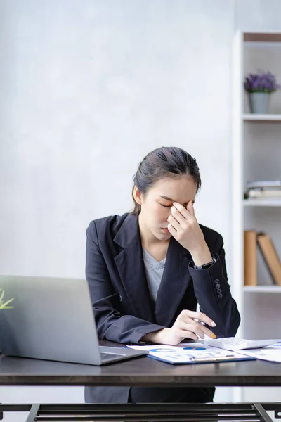 ラップトップの前で会計作業から頭痛の概念を持つストレスアジアの実業家女性女性は仕事で頭痛や慢性疲労に疲れています オフィス症候群の概念 — ストック写真