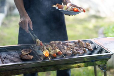 Barbekü partisi yaz yemeği ızgara et Mutlu arkadaşlar ızgara et, barbekü partisi ve bira kutlaması konsepti eğleniyor