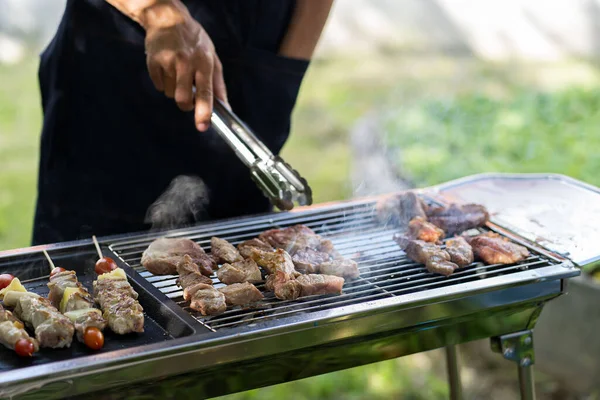 barbecue party food summer grilled meat Happy friends are having fun grilling meat, enjoying a barbecue party and beer celebration concept