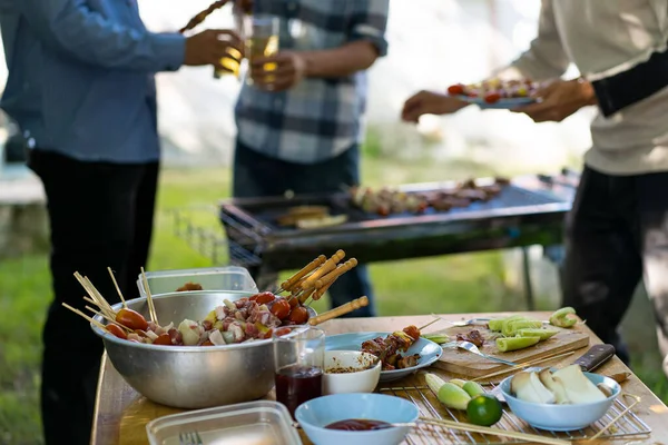 barbecue party food summer grilled meat Happy friends are having fun grilling meat, enjoying a barbecue party and beer celebration concept