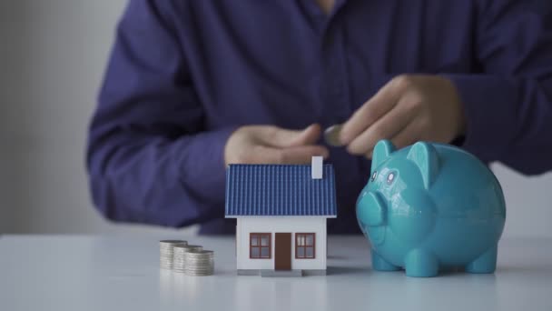 Jovem Coloca Uma Moeda Banco Porquinho Para Compra Uma Casa — Vídeo de Stock