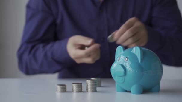 Jeune Homme Qui Met Des Pièces Dans Une Tirelire Économisant — Video