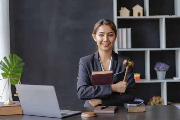 Brass judge on lawyer\'s table with a female lawyer sitting in the background trial and law Judiciary and Legislative Counseling Concepts