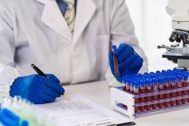 Laboratuvar asistanı deneysel bir kan damarı buldu. Tıbbi araştırmacılar mikroplardan korunmak için lastik eldiven takarlar. Laboratuvar araştırması yapan hastaların kan damarlarını göster.