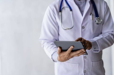 Erkek doktor hastalarla internet üzerinden bilgisayar, dizüstü bilgisayar, akıllı telefon ve tablet üzerinden konuşuyor. Telekonferans telekonferans gibidir..
