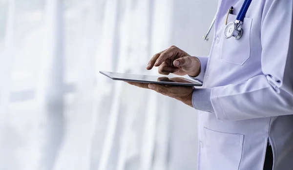 Male doctor talks to patients online via video call via webcam on computer, laptop, smartphone, tablet. Teleconference is like a teleconference.