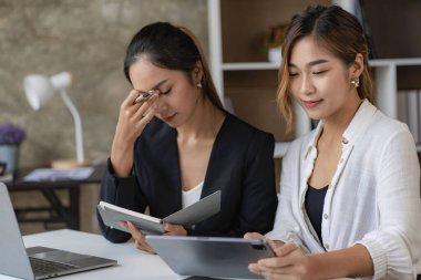 2 Asyalı kadın muhasebe kavramında dizüstü bilgisayar kullanıyor