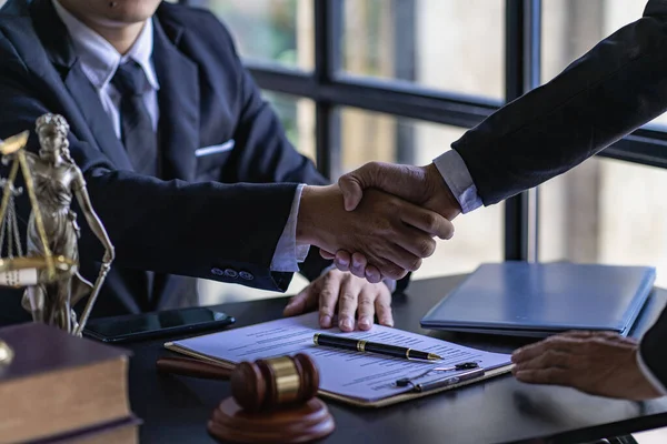 Businessmen shake hands to seal a deal with a partner lawyer or a lawyer who discusses contract agreements, advice, legal services.