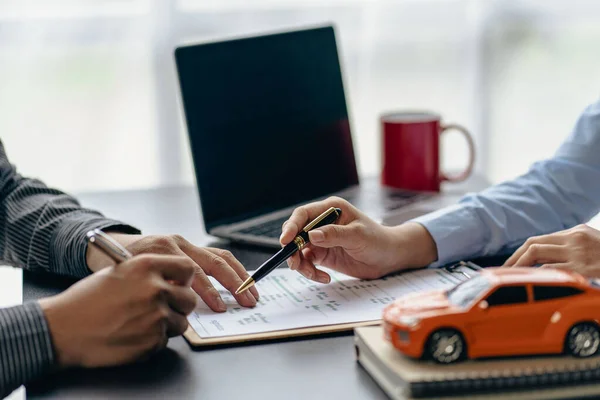 Car rental agent managers with new car owners sign a good rental agreement after passing vehicle financing.