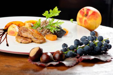 Güzel yemekler, kavrulmuş kaz ciğeri, kahverengi pirinç ve kuru meyve.