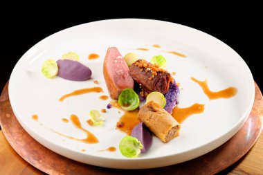 Güzel bir restoranda kızarmış ördek, kırmızı lahana rulosu ve kuru meyve.