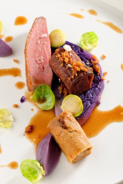 Güzel bir restoranda kızarmış ördek, kırmızı lahana rulosu ve kuru meyve.