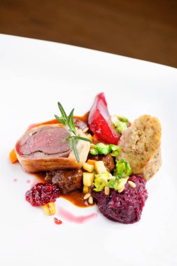 Güzel bir restoranda kızarmış ördek, kırmızı lahana rulosu ve kuru meyve.